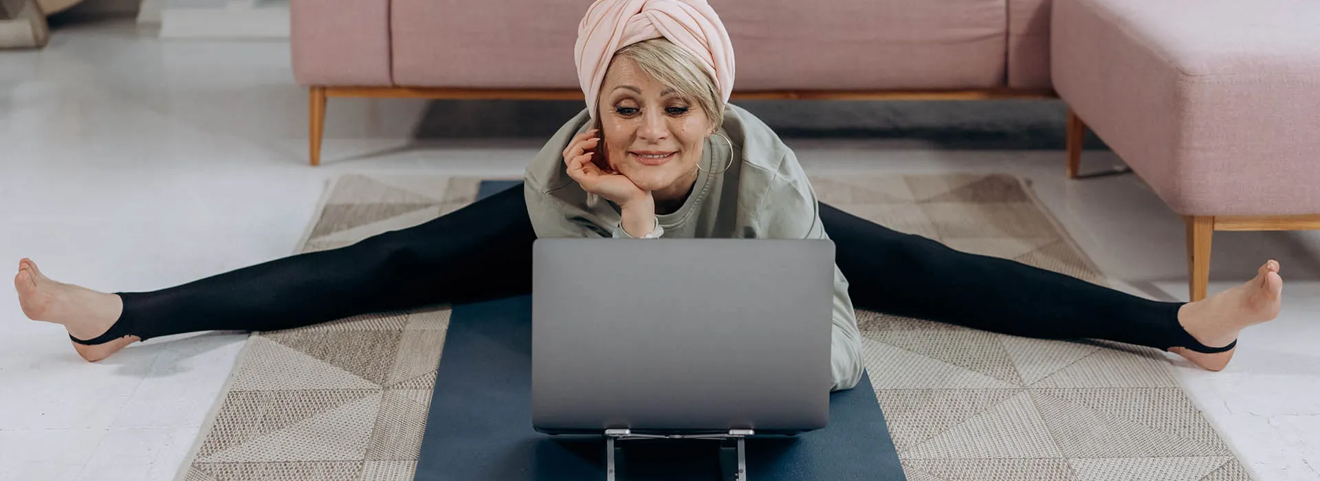 woman doing splits looking at laptop